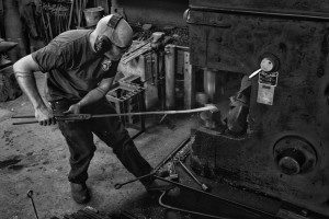 Blacksmith James Price forging on a power hammer