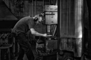 Blacksmith James Price forging under his power hammer