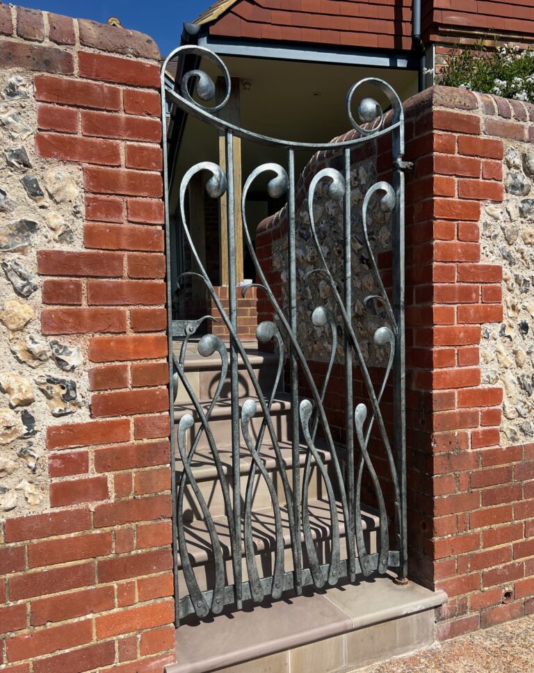 Sculptural gate in hand forged wrought iron with an organic fluid design based upon plants