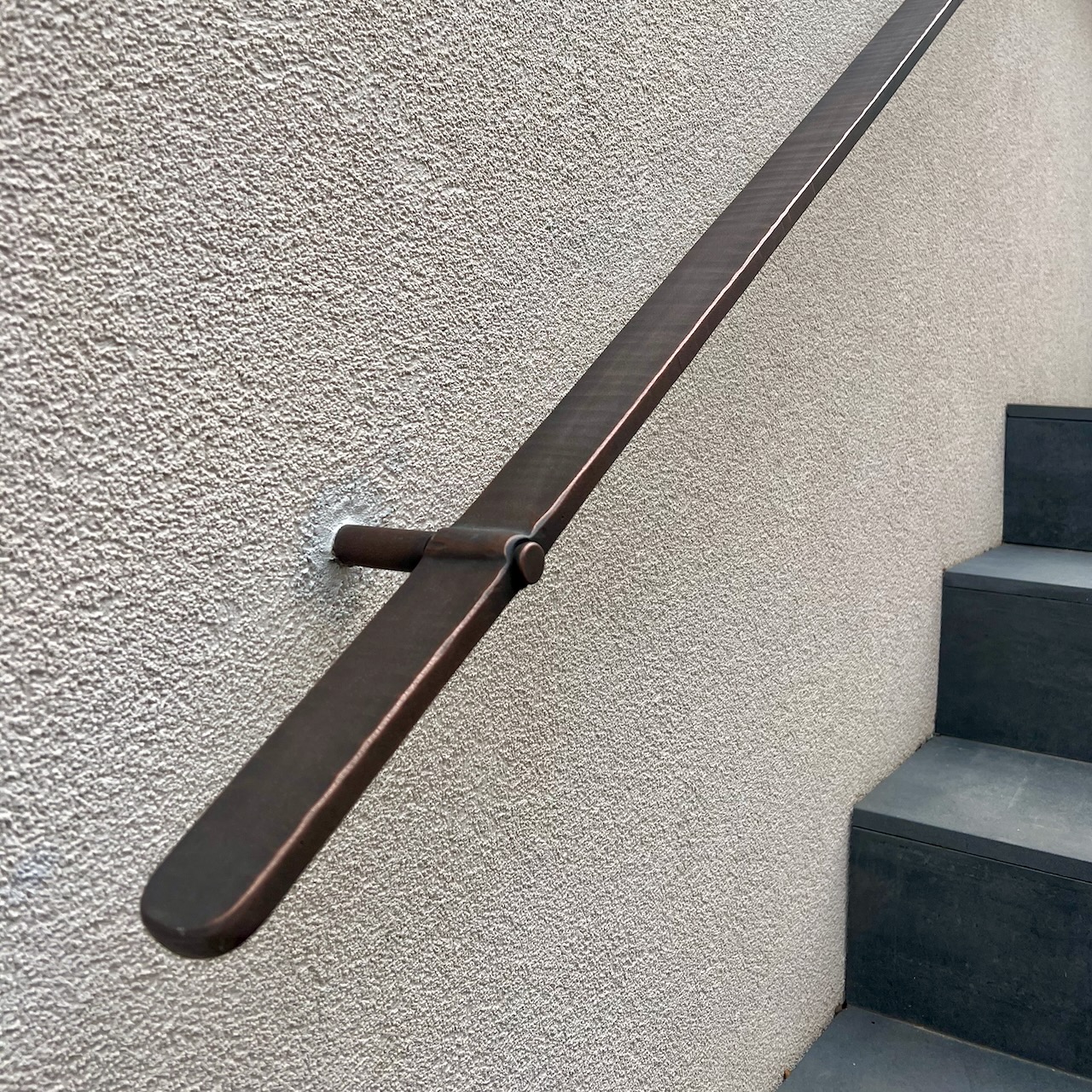 Modern bronze handrail in forged patinated  bronze 