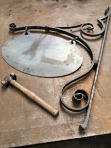 Wrought iron house sign hand forged using traditional blacksmith techniques