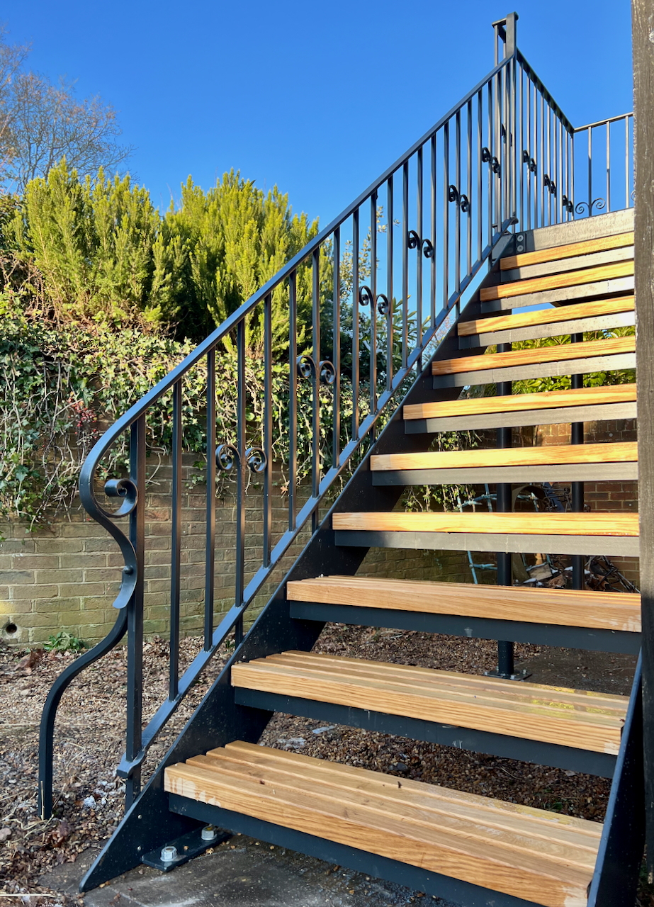 Wrought iron staircase with oak treads hand forged for a Sussex barn