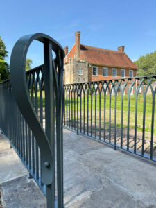 Hand forged wrought iron railing with gothic arch design for a sussex garden