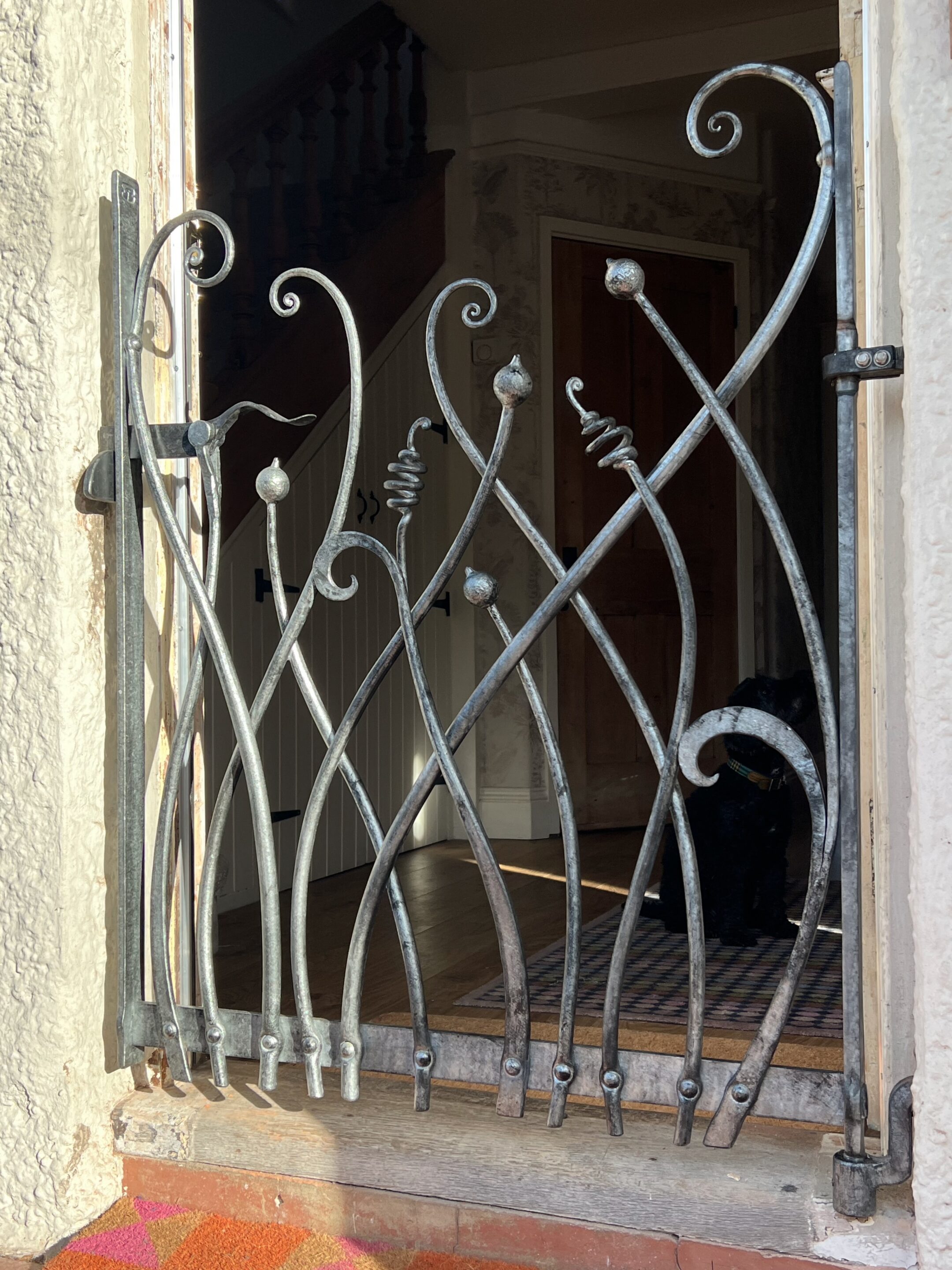 Hand forged iron gate with an organic feel inspired by plants and seed heads