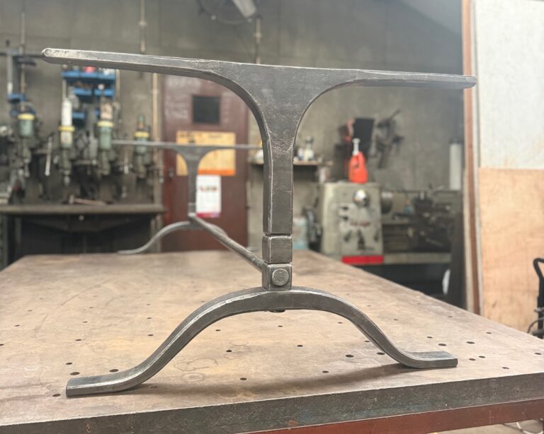 Wishbone table in hand forged iron with a burnished patina finish