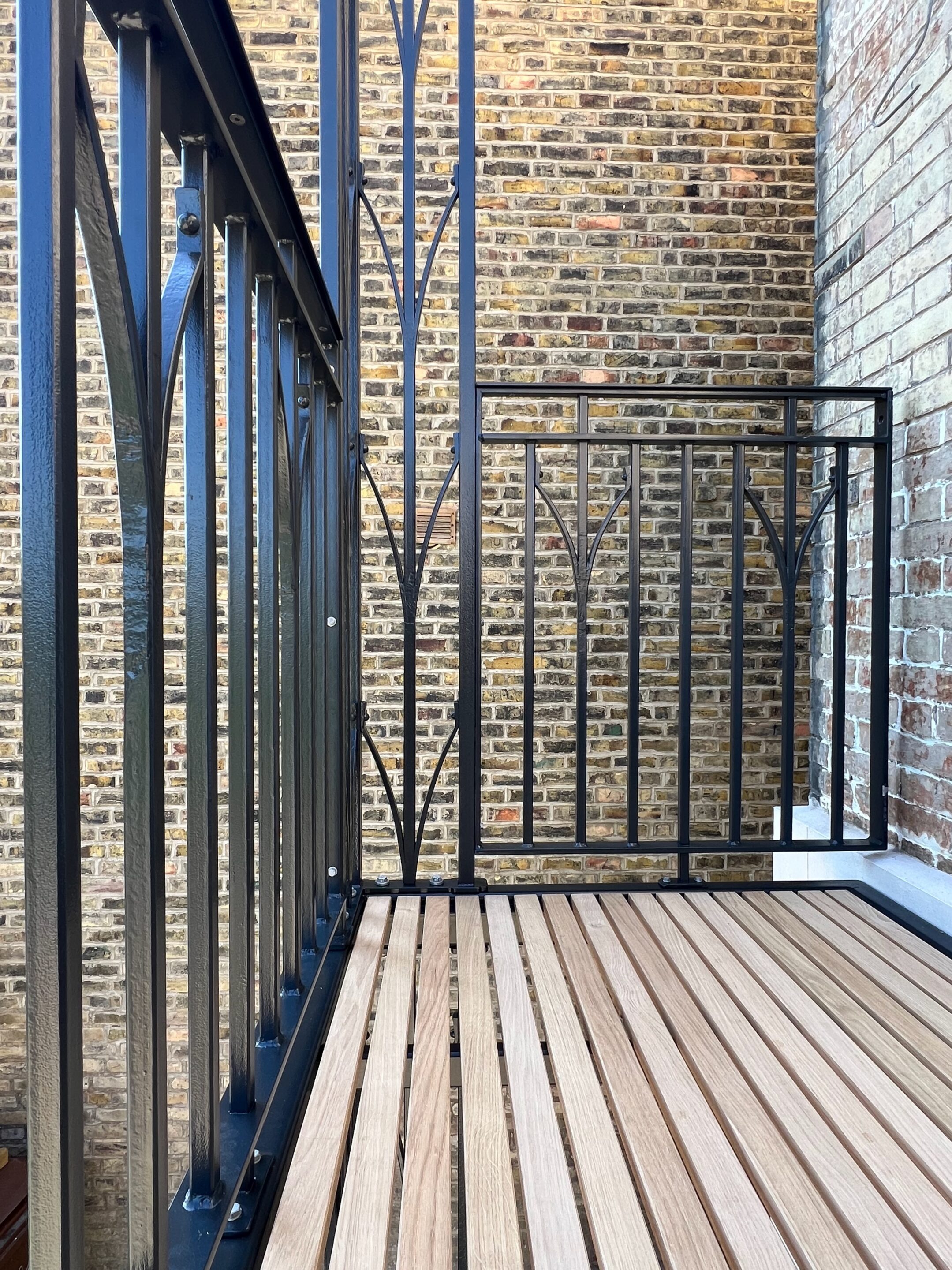 oak deck on a bespoke wrought iron balcony made by james price blacksmith
