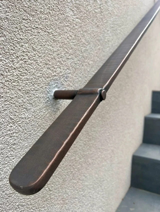Making one of our Edge handrails this morning, forged in stainless, beautifully simple with a slight fullered texture. Hot punched on edge the ‘hard way’ with little room for error. So much so that using the hydraulic press isnt an option with these. Love this design. This one will be in patinated bronze as with the original. Swipe to see process……#forged #blacksmithdesigner #handrail #process #bronze #hardware  #architecturalmetal #architecturaldetails #iron #metaldesgn